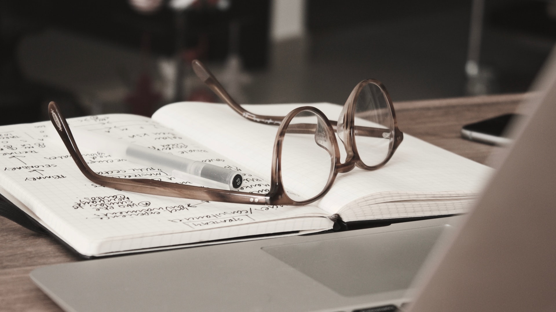 glasses and to do list on desk